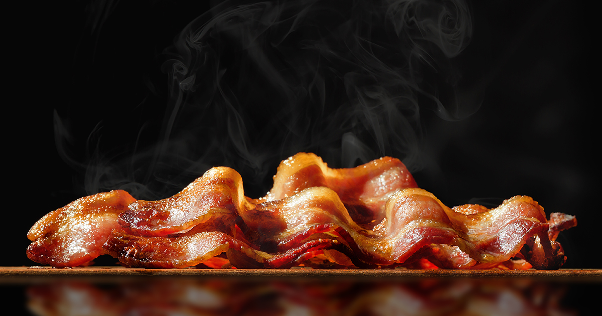 Pile of Sizzling Bacon Isolated on Black