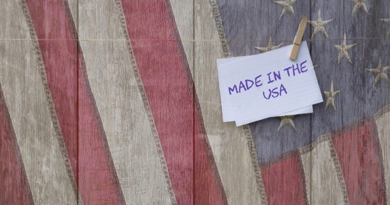 Made in the USA message, USA patriotic old flag on weathered wood background with note Made in the USA