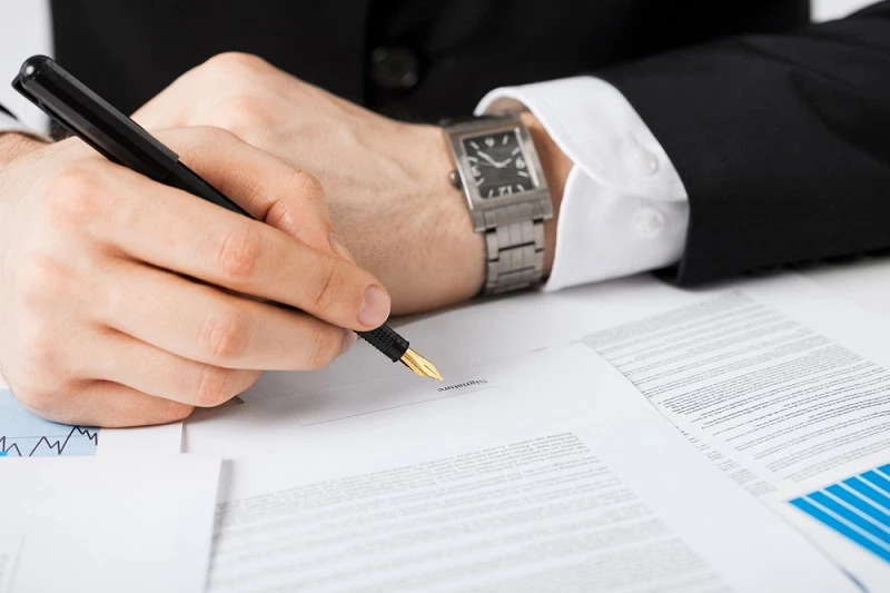 man signing a paper contract with a pen man signing a paper contract with a pen