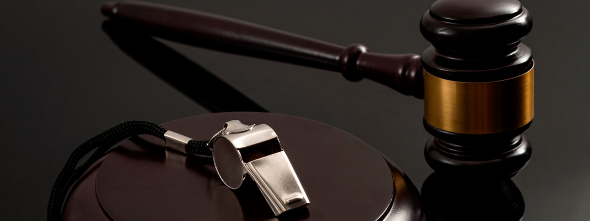 Whistleblower protection law and freedom of information legislation conceptual idea with metal whistle and wooden judge gavel on dark background