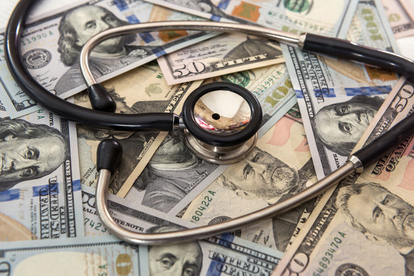 doctor stethoscope lying on a lot of  Dollar banknotes