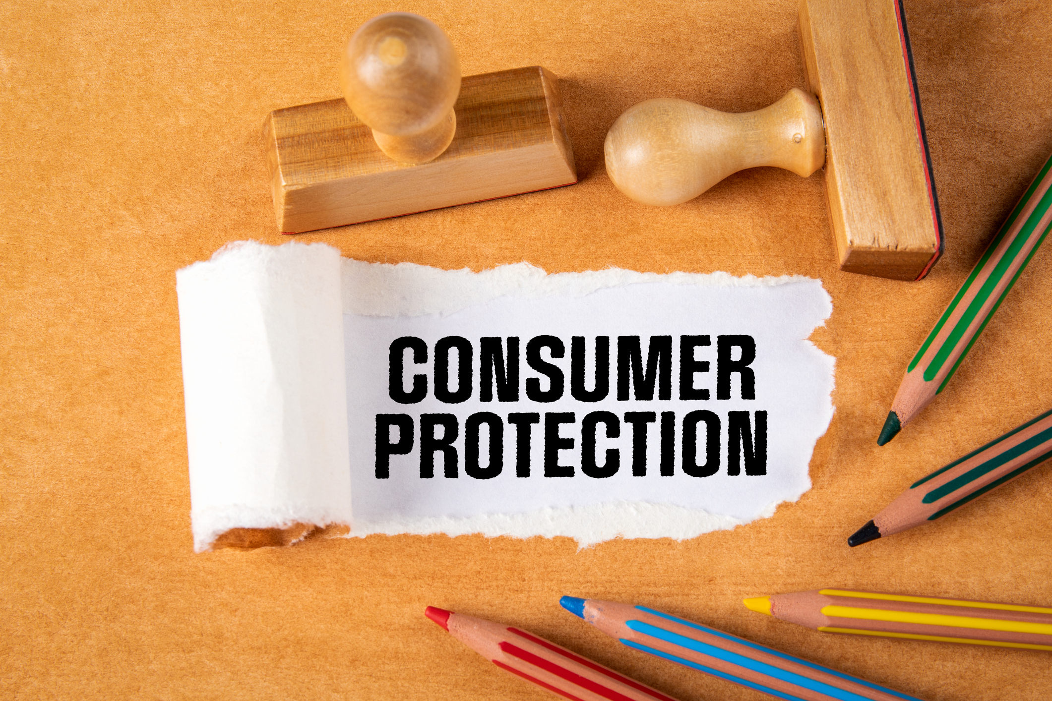 Consumer Protection. Laws, regulations and data security. Pencils, wooden stamps on orange paper