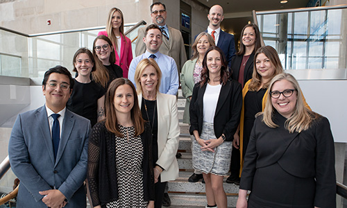 "group of smiling people standing on steps"