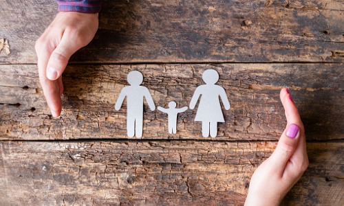 "paper cutout of family on wood"