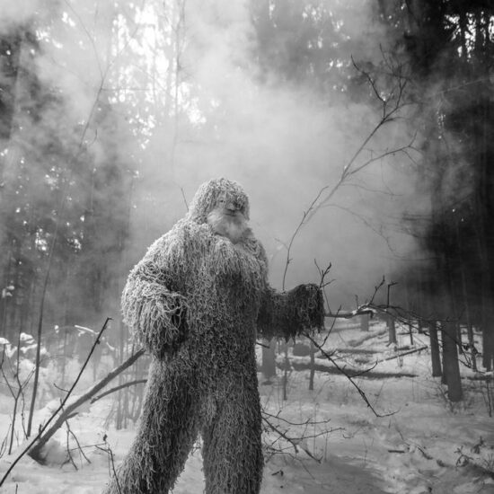 Yeti fairy tale character in winter forest. Outdoor fantasy black-white photo.