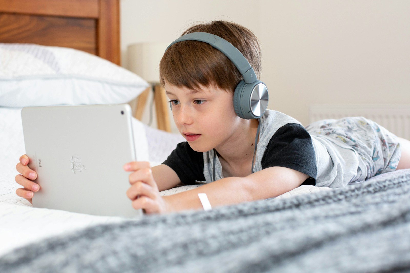 Boy using iPad with headphones on