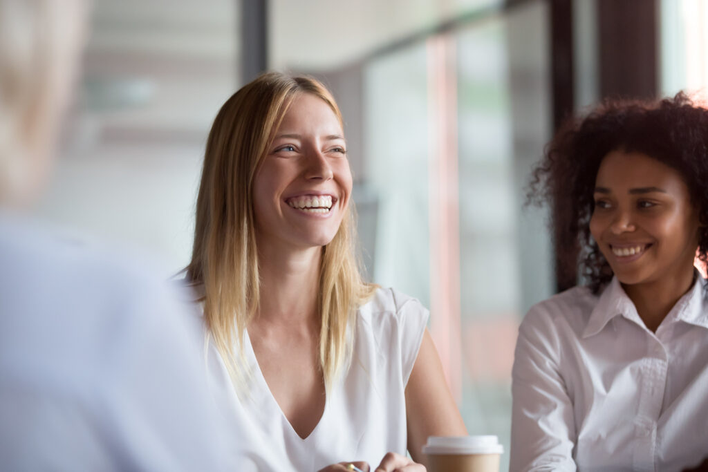 mentoring circles, Happy young businesswoman coach mentor leader laughing at funny joke at group business meeting, joyful smiling millennial lady having fun with diverse corporate team people engaged in talking at work