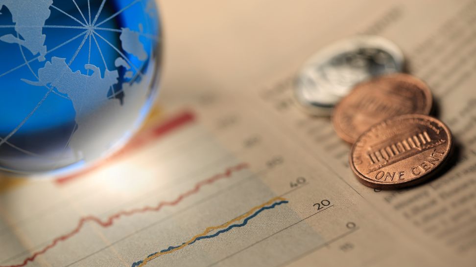 crystal globe and coins on financial graph