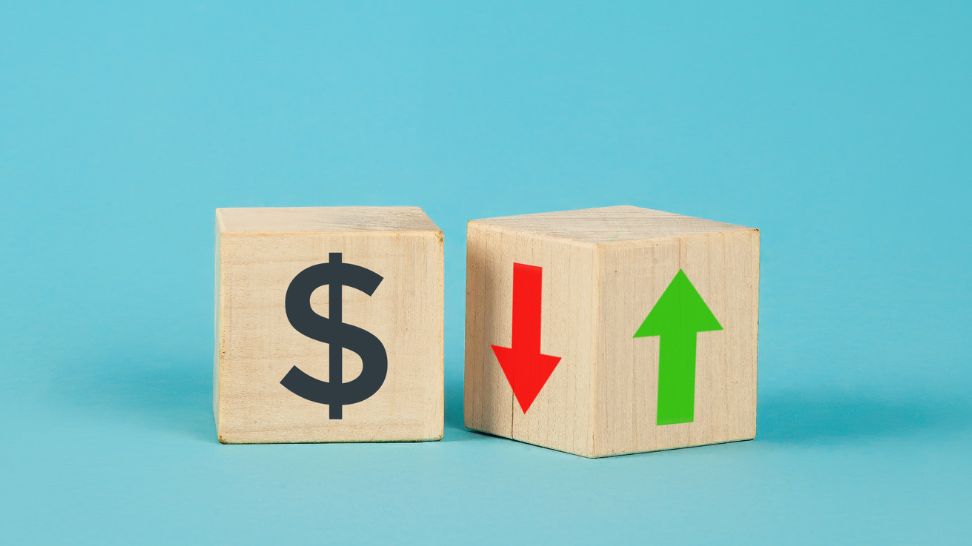 wooden cube with dollar sign up and down arrow