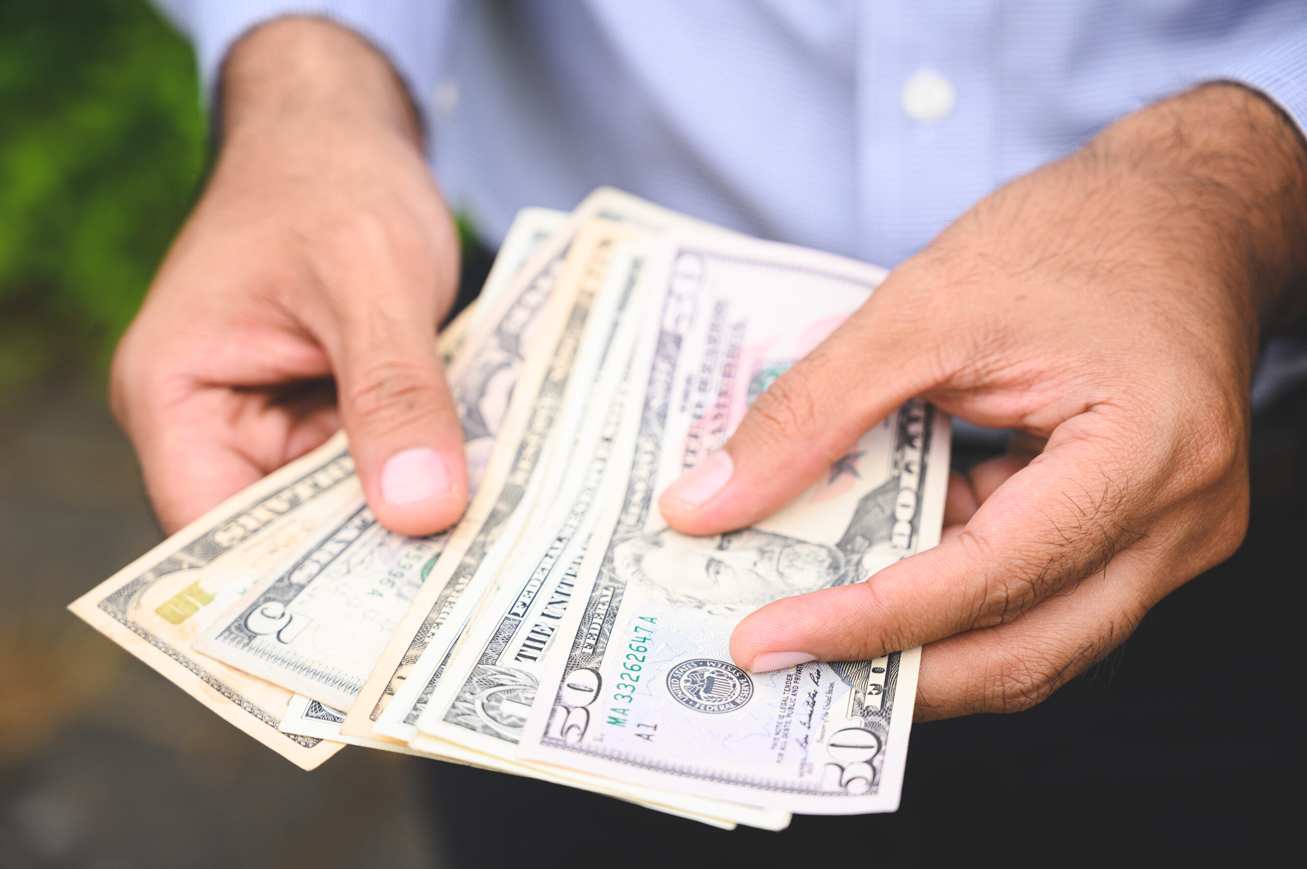 Close up people hand hold count the money spread of cash. Concept finance Saving money.