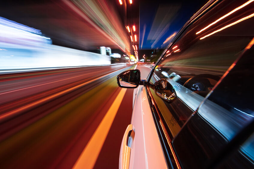 Car driving at night in a city