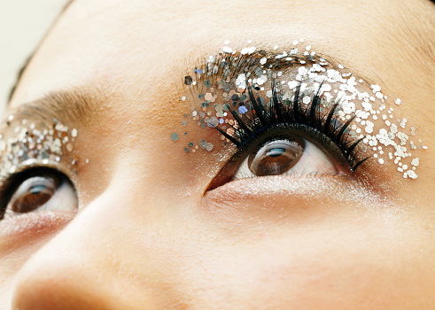 Woman's eyelid with silver color glitters