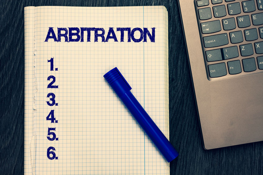 Text sign showing Arbitration. Conceptual photo Use of an arbitrator to settle a dispute Mediation Negotiation Open notebook squared page black marker computer keyboard wooden background.