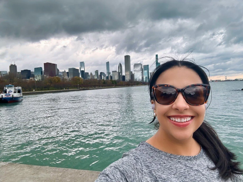 Woman smiling along Lake Michigan with Chicago skyline in background