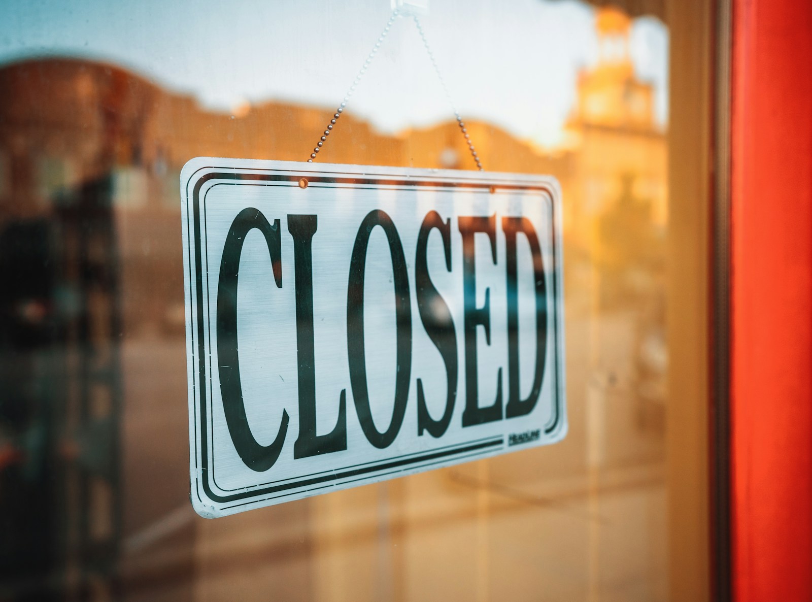 The sun had just tipped beneath the buildings across the street, and the town was beginning to settle into dusk. This sign stood boldly out from the sharp red of the doorframe and the soft gold light that surrounded me.