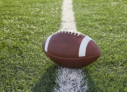American football ball in field at 20 yard line