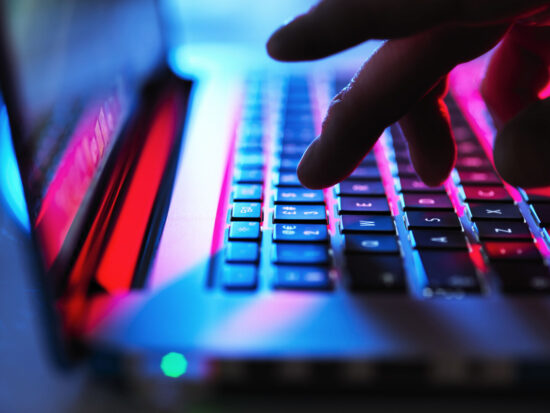 GettyImages-1175885065_typing at his laptop computer at night