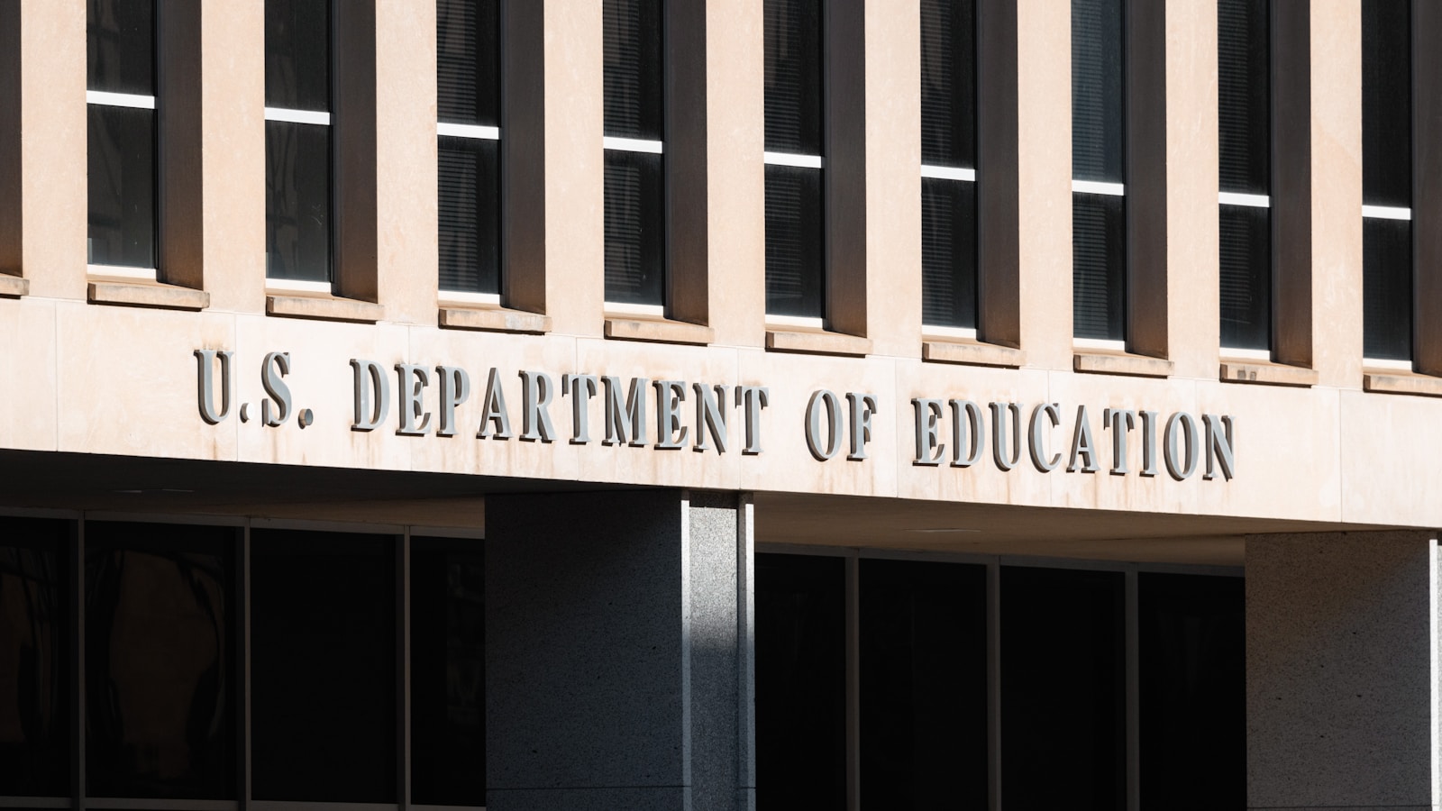 Front facade of the U.S. Department of Education building in Washington D.C., featuring large, bold letters spelling out its name.