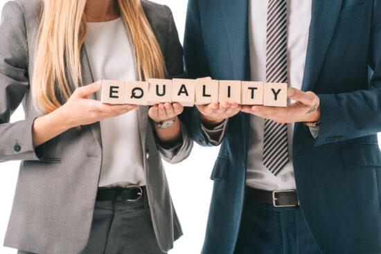 cropped view of businesspeople holding alphabet cubes with equality word, isolated on white
