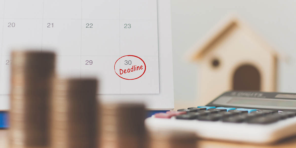 Tax payment season and finance debt collection deadline concept. Money coins stack, calendar, calculator and wooden house