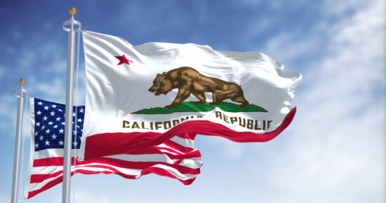 The California state flag waving along with the national flag of the United States of America