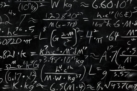 Math equations and formula written in chalk on messy chalkboard