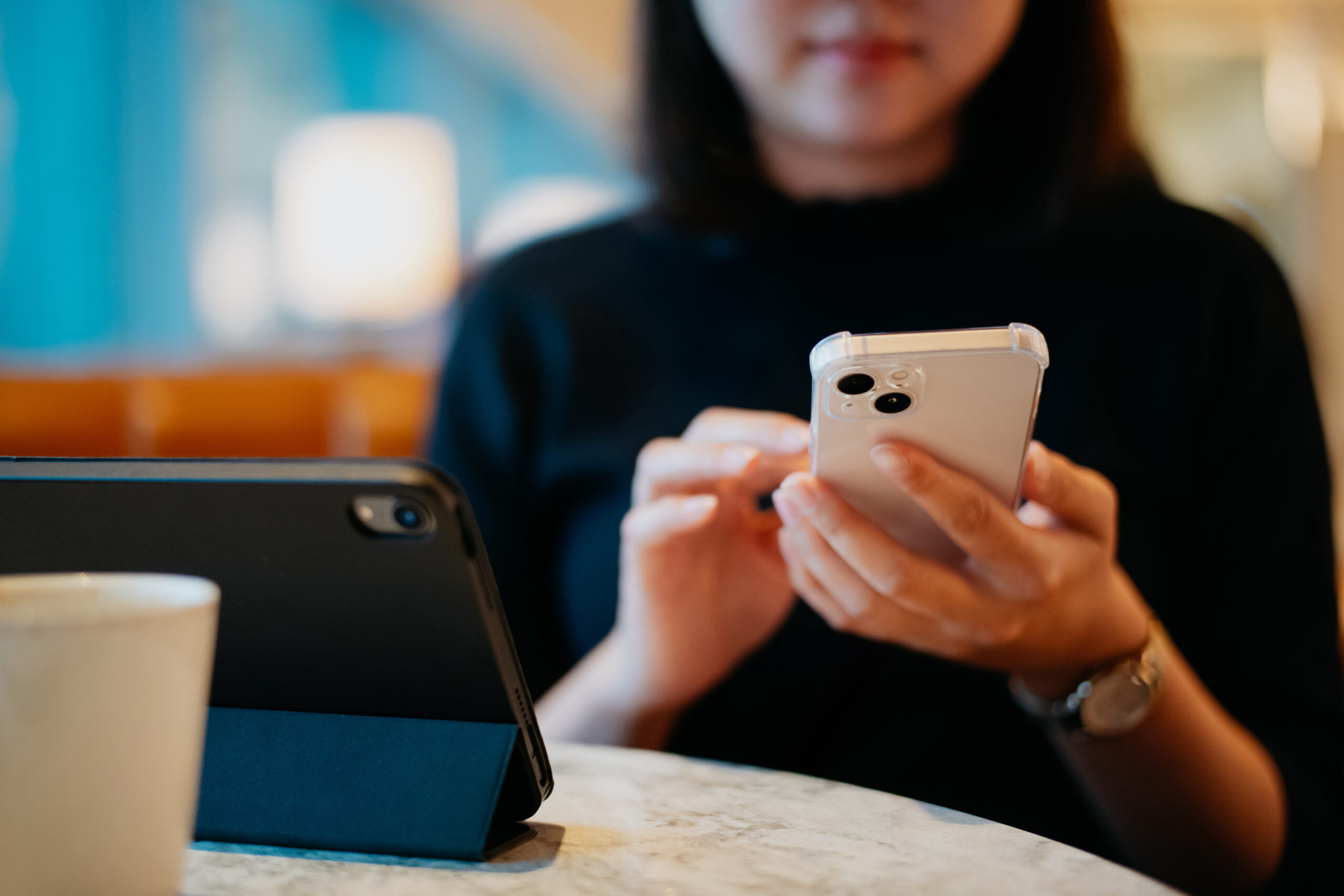 Asian businesswoman using smartphone in airport lounge