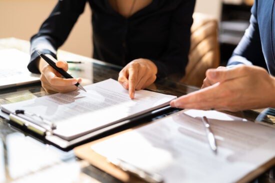 Two Businesspeople Working On Contract Paper