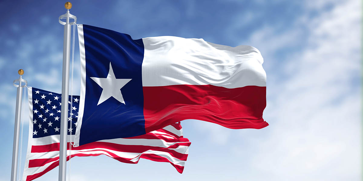 The Texas state flag waving along with the national flag of the United States of America