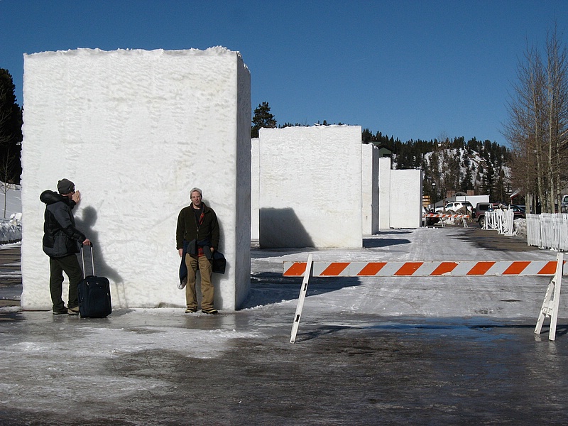 Just before the snow sculpting competition starts, with artists standing next to a giant block of ice/snow.