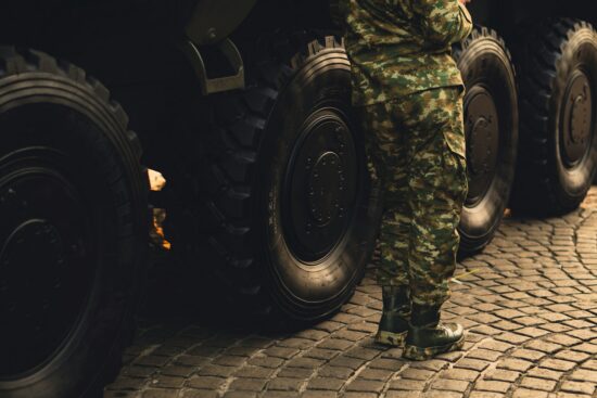 An army man resting beside an APC.