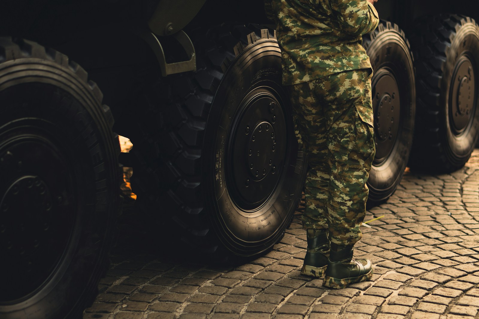 An army man resting beside an APC.