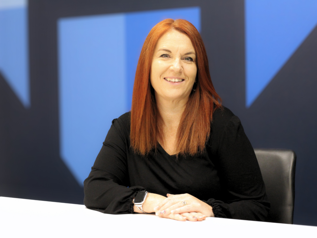 Carrie Lewis of Howells Solicitors sits smiling in a meeting room