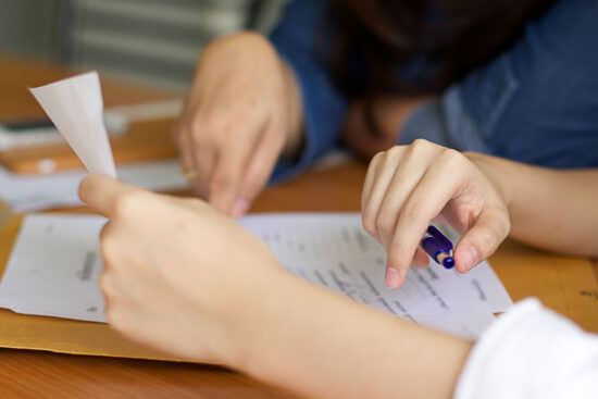 Businesswomen filling paperwork for agreement