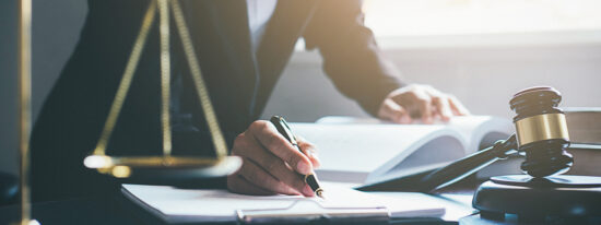 Justice and Law concept. Legal counsel presents to the client a signed contract with gavel and legal law or legal having team meeting at law firm in background