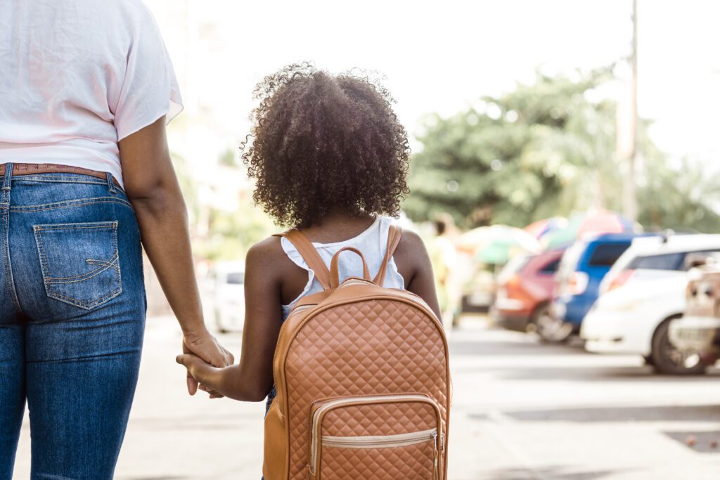 little girl with backpack holds a person's hand. back to school concept. Loyola Anti-Bullying Project