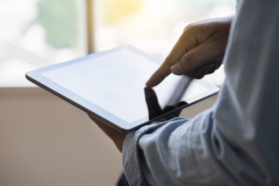 Digital tablet computer close up man using tablet hands man multitasking with isolated screen