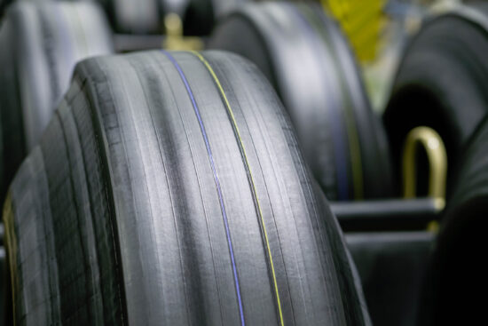 Tyre manufacturing production in factory warehouse, Green tire radial, extruded rubber layers preparing to mold for the curing process, car logistic transportation industry