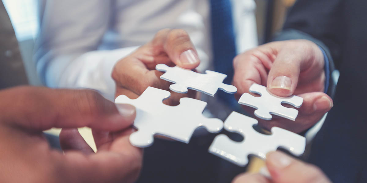 Group of business people holding a jigsaw puzzle pieces.