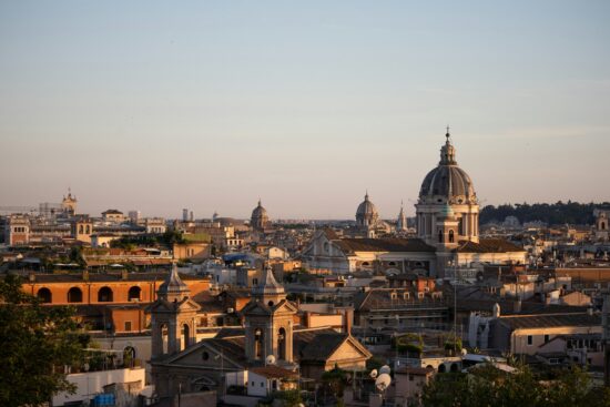 Golden hour bathes Rome’s sea of domes and bell towers, stretching toward the horizon in warm haze.
