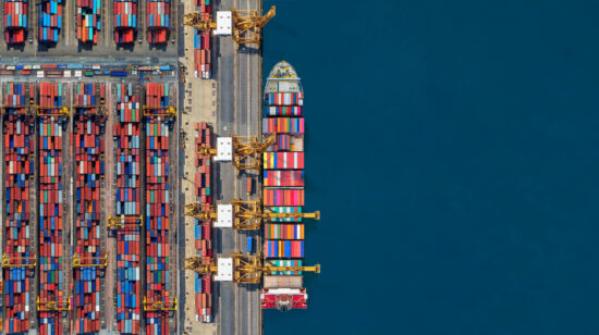 Industrial import-export port prepare to load containers. Aerial top view container ship in export and import global business and logistic. Global transportation and logistic business.