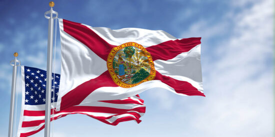 The Florida state flag waving along with the national flag of the United States of America