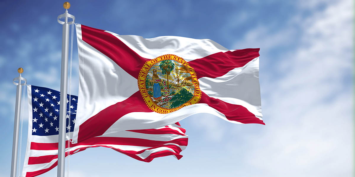 The Florida state flag waving along with the national flag of the United States of America