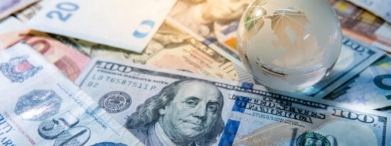 Global business and economy. World globe crystal glass on various international money banknotes. Currency exchange rate. Financial investment concept-shutterstock_1208760601