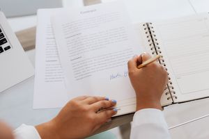 https-hkklawoffices-com-wp-content-uploads-2026-08-close-up-of-hands-signing-a-contract-on-a-desk-with-office-supplies-symbolizing-legal-agreements-5387258-300x200-jpg