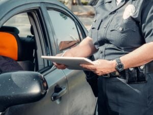 No Ticket, No Arrest, Still a Case: What a Wrongful Police Stop Is Worth 7 Police officer writing a citation beside a vehicle during a traffic stop.