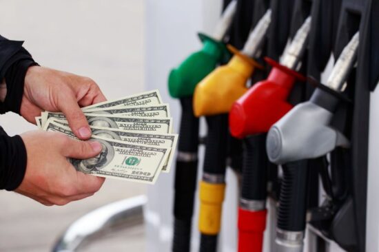 90059738 - dollars in a hands on the background of colorful fuel nozzles