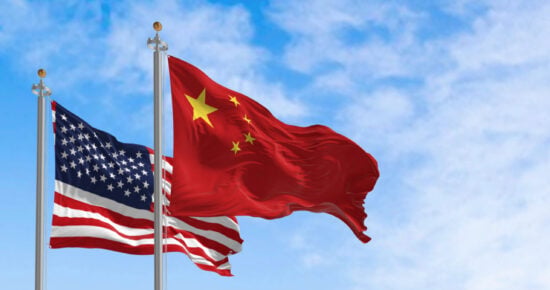 National flags of China and the United States waving in the wind on a clear day