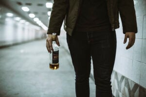 Is Being Drunk in Public a Crime in California? What Penal Code § 647(f) Really Requires 7 Person walking through a tunnel while holding a bottle of liquor.