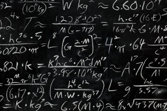 Math equations and formula written in chalk on messy chalkboard